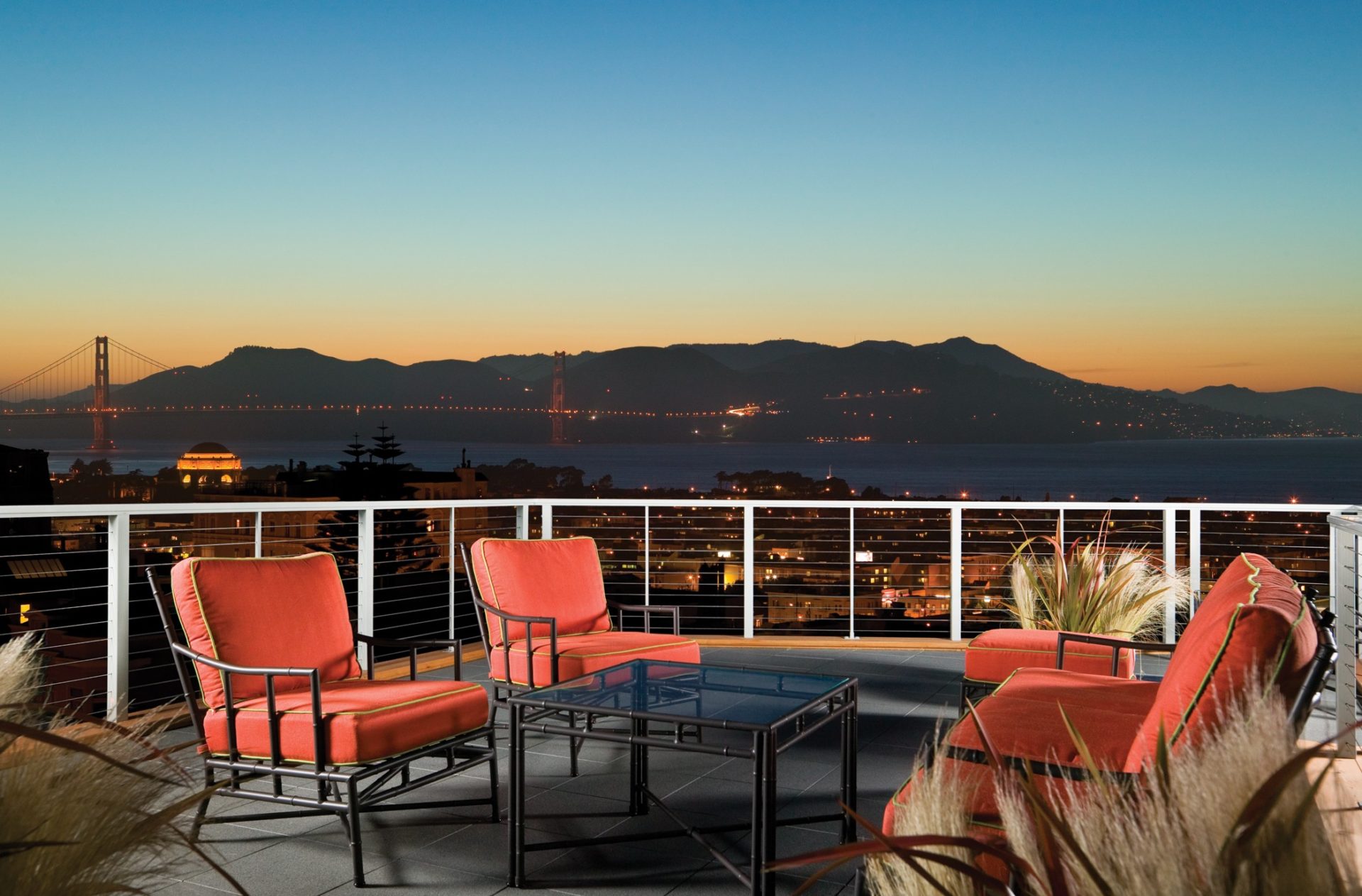 Rooftop deck in Pacific Heights neighborhood of San Francisco with custom cable railings and a view of the Golden Gate bridge at night