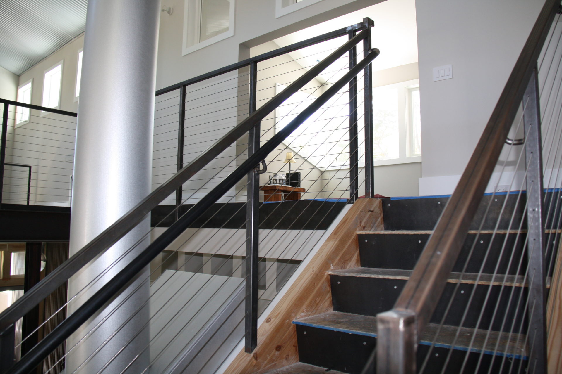 black metal cable railing being installed to a residential stairwell in san mateo ca