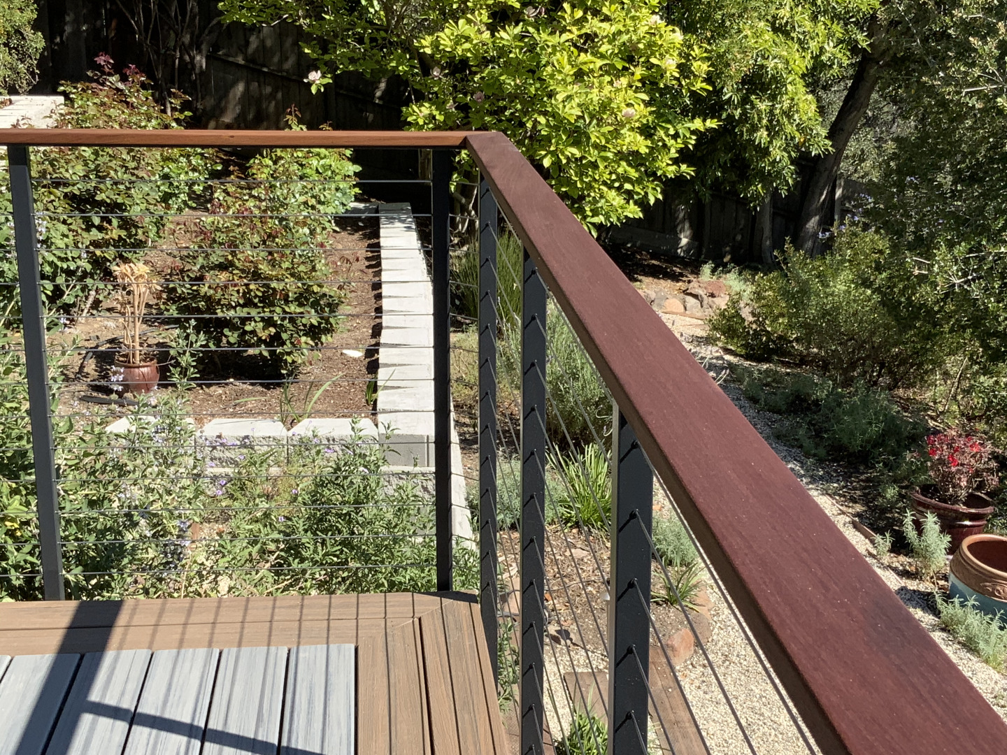 cable railing fascia-mounted on deck with wooden handrails